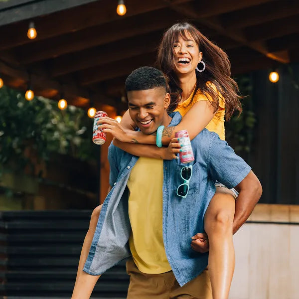 Girl getting a piggy back ride holding Pura Sodas